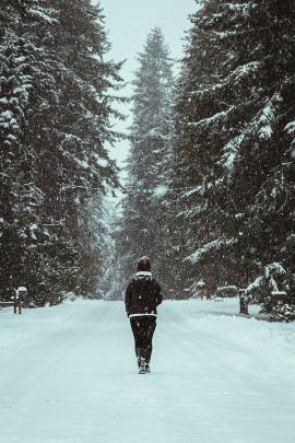 A woman walking through snow-covered suburban streets