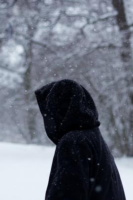 Hooded figure in snow.