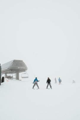 skiers getting off the lift on a foggy day