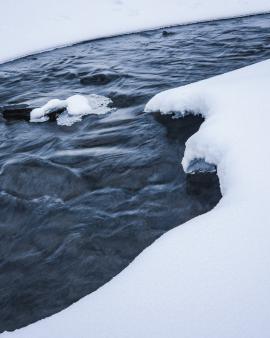 A river carves its way through the snow