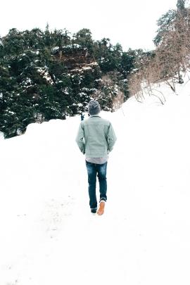 man hiking on beautiful snow covered trails on a mountain.