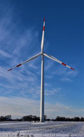 Wind Turbine Pin wheel in the blue sky and in the winter wonderland landscape