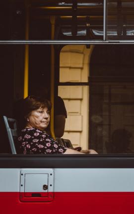 Woman starring out of the window of a tram in Prague.