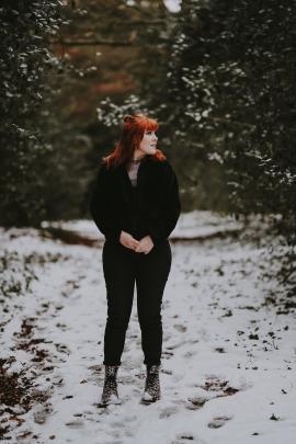 Woman in black, forest path, snow